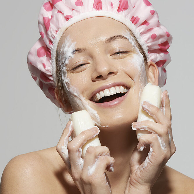 woman washing her face with soap