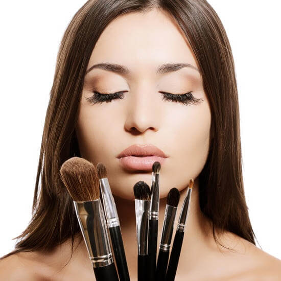 woman holding makeup brushes