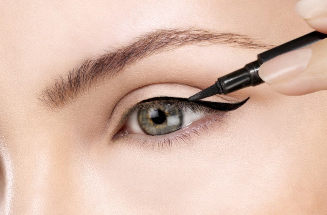 woman is using eyeliner